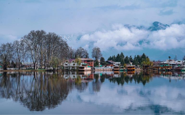 Peaceful Lakeside Town Surrounded by Foggy Mountains