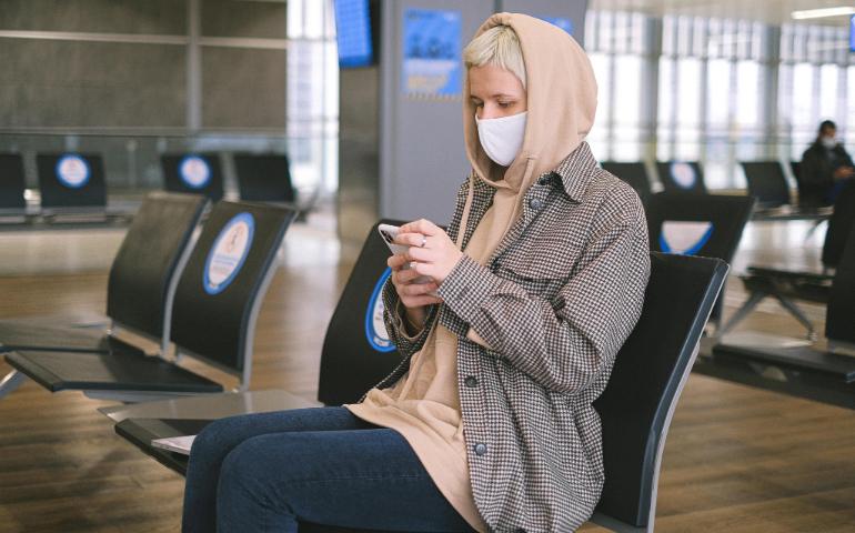 A Woman Sitting in an Airport Waiting Area Using Her Smartphone