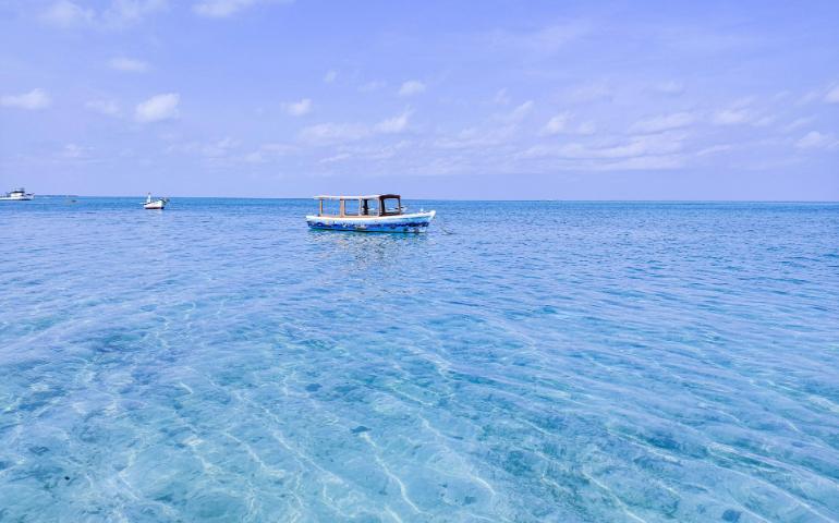 Small boat sailing through the clear waters of Lakshadweep