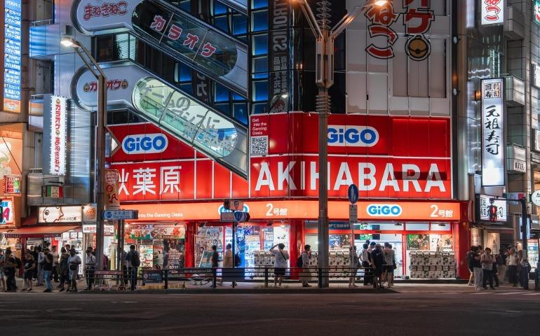 Crowds move past the bright red GiGO arcade and bold AKIHABARA signage in Akihabara, Tokyo