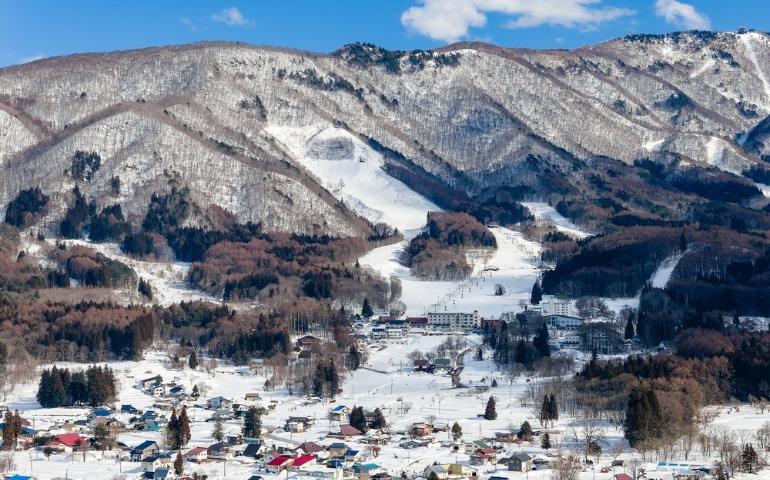 Aerial view of Komaruyama ski area and snowy village in Kita-Shiga Kogen