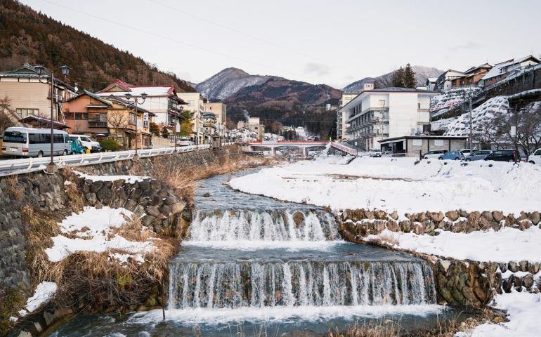 Yokoyugawa river with waterfall passing through the Shibu Onsen in Japan