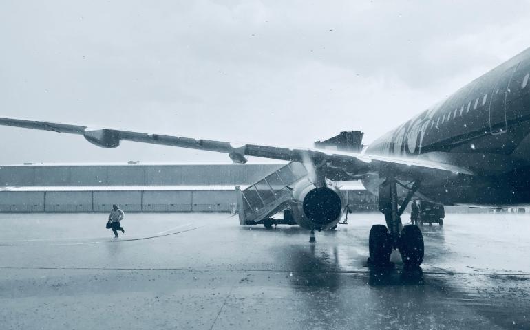 Person running on runway during rain
