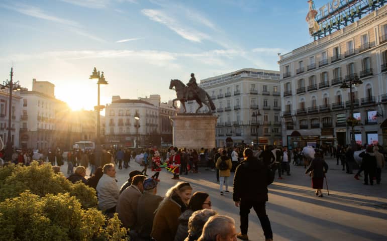 Sun peaking over buildings in Puerta del Sol, Madrid.