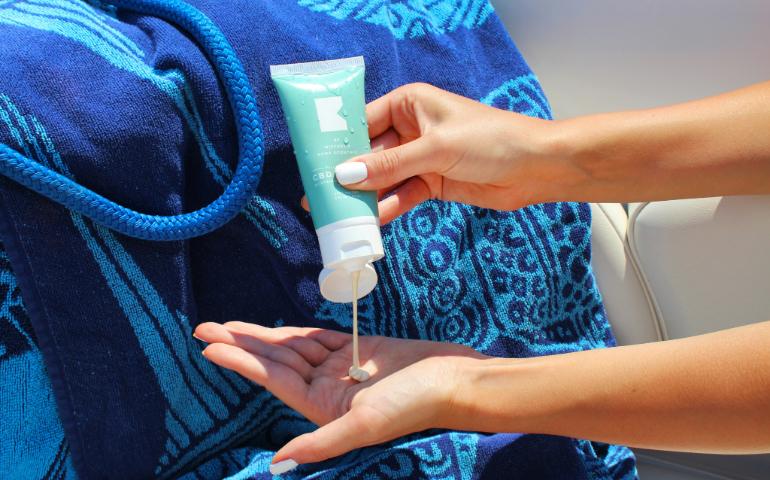 Person holding sunscreen bottle