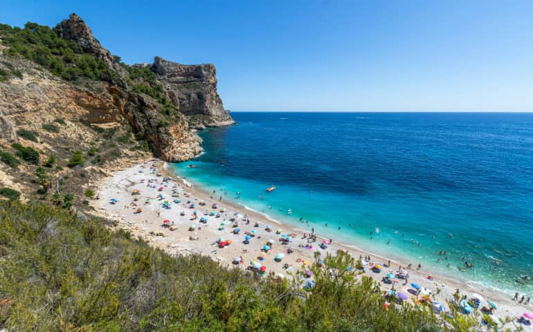 People enjoying at the Cala del Moraig Beach in Spain