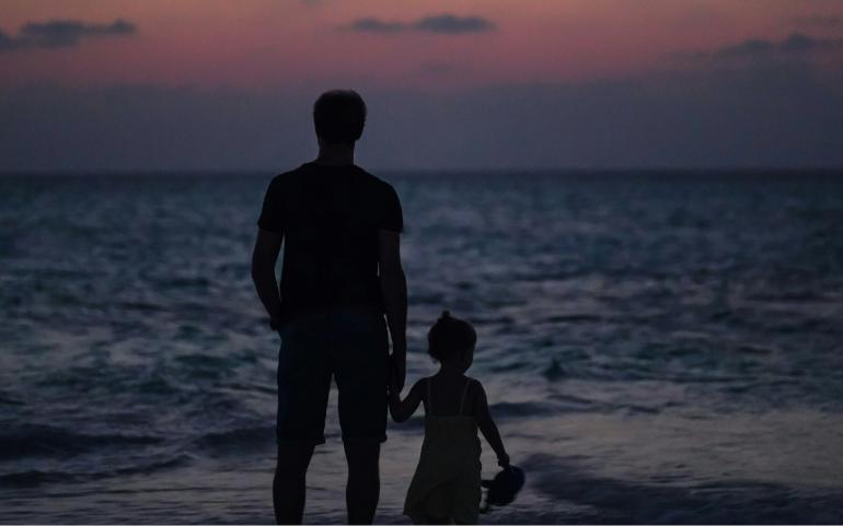 Father and Daughter watching beautiful Maldivian sunset