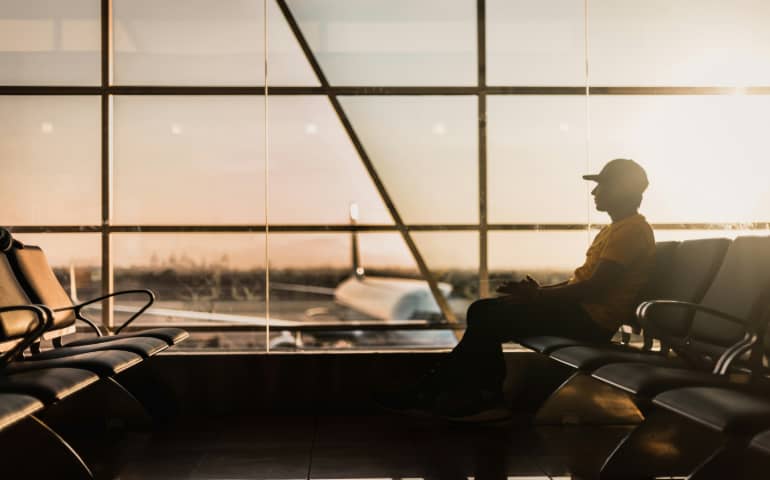 A man sitting near the window at the airport.
