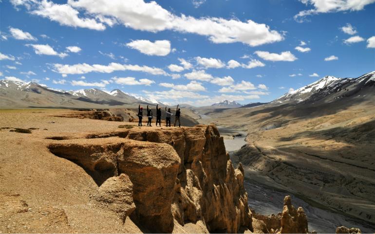 Group of people standing on a cliff near the Leh-Manali highway
