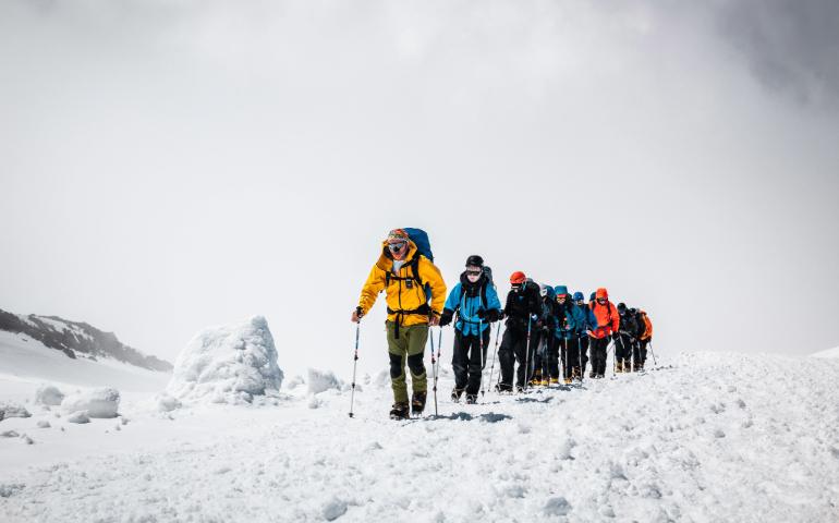 A group of mountaineers ascending a snowy mountain.
