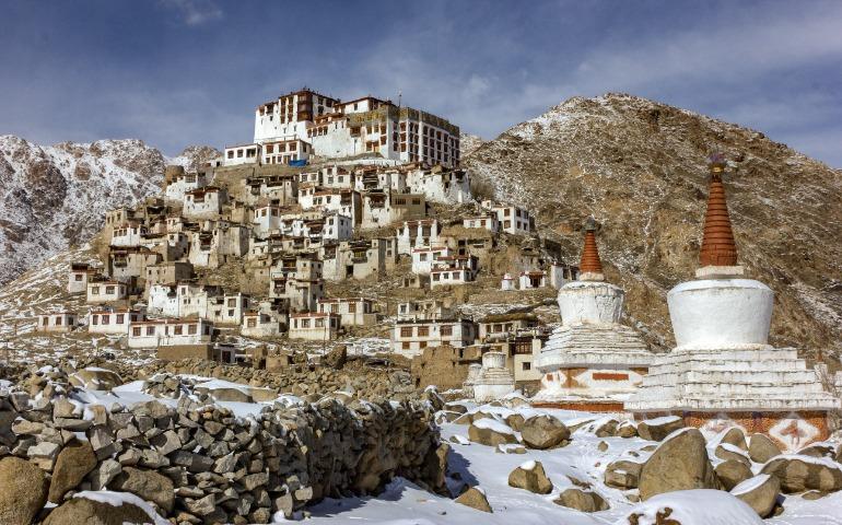 Monastery set against a scenic snowy mountain landscape