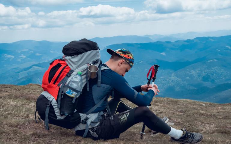 Man resting with backpack on a mountain top 