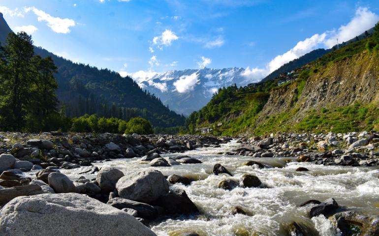 Flowing River Through Rocks with Mountain Backdrop