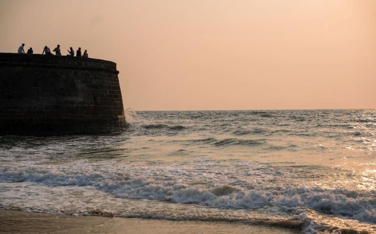 A historic fort wall during a peaceful Goa sunset by the sea