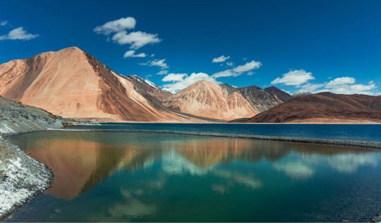 Pangong Lake with majestic Himalayan mountains under a clear blue sky.
image Credit: Anjali Vishwakarma/Pexels