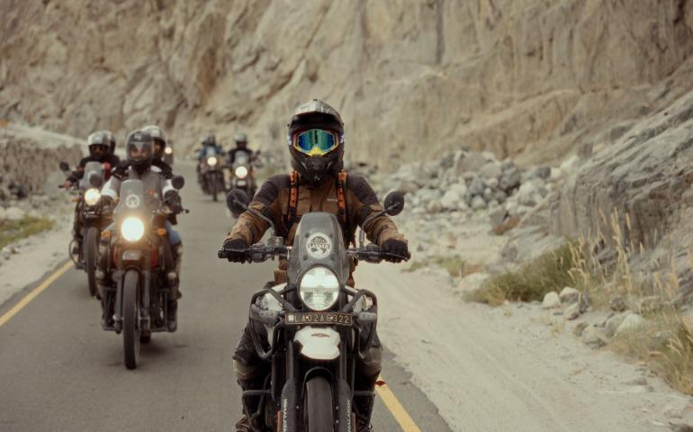 Motorcyclists riding through scenic mountain roads, showcasing adventure and freedom