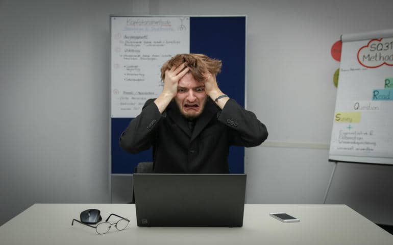 A man in shock sitting in front of the computer
