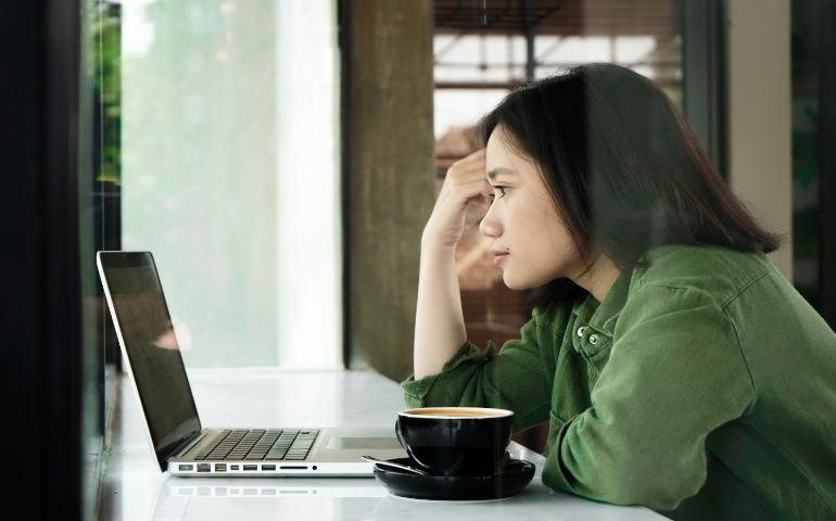 A person sitting in front of a laptop