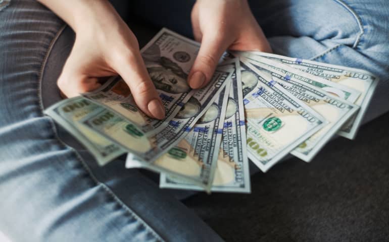 A girl holding several dollars in her hand
