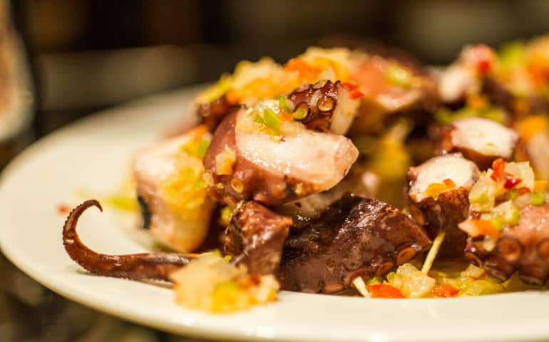 A white plate topped with meat and vegetables