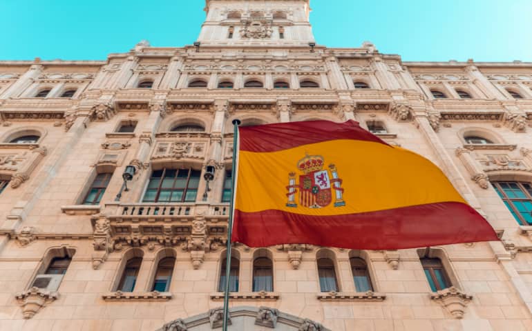 The flag of Spain in front of a building