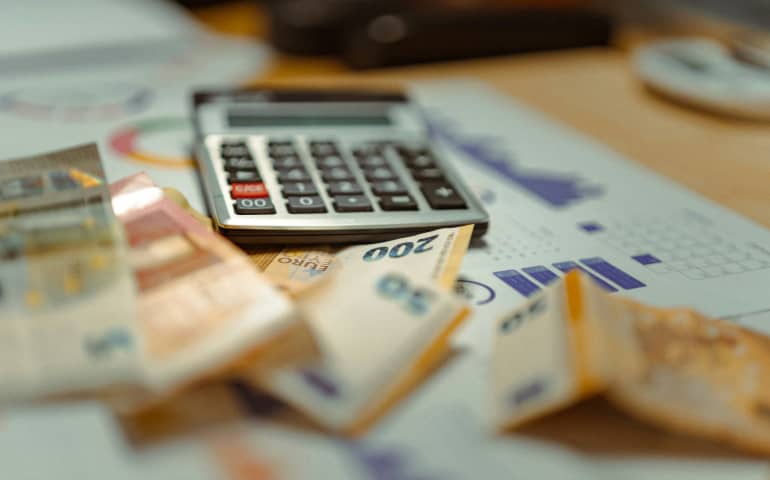 A calculator, money and a daily budget sheet