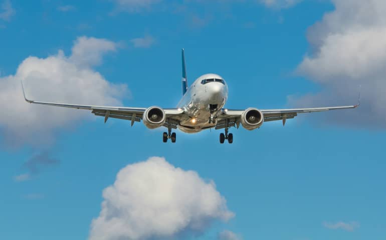 White airplane below blue sky
