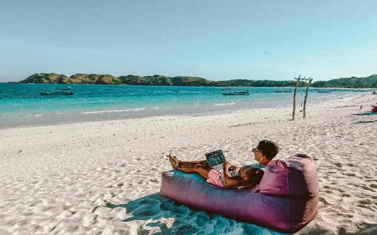Traveller working on the beach