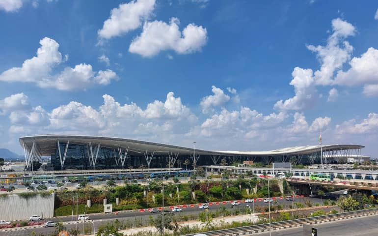 Lovely sunny day with cumulus clouds over the T1 Terminal of Bengaluru airport in Karnataka, India. 
