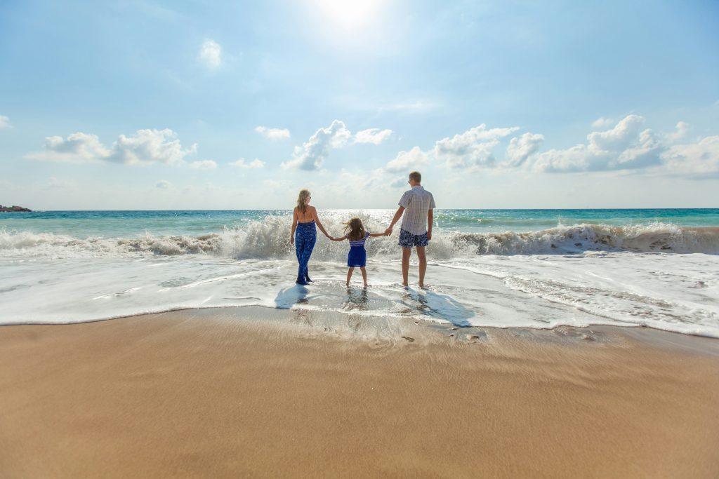 A family holding hands on the seashore
