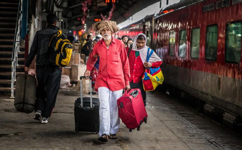 Travelers in a bustling train station with luggage, showcasing everyday life in transit