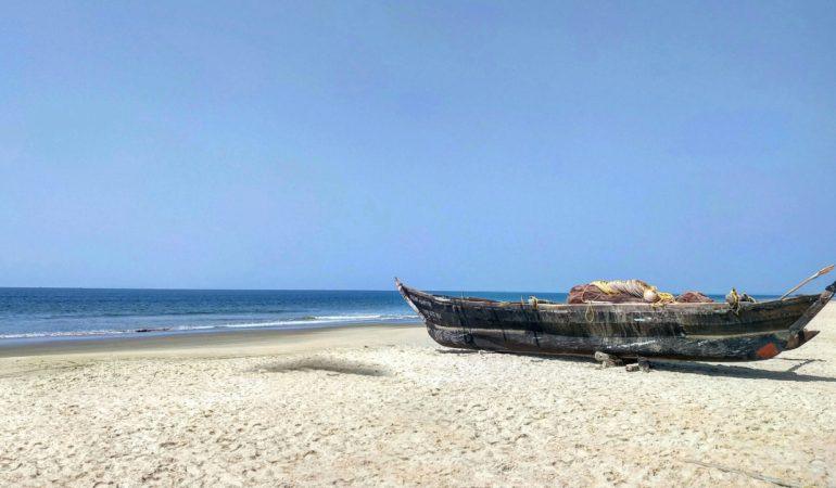 dyllic beach scene in Goa, India with a wooden fishing boat and calm sea
Akhter Jan/Pexels