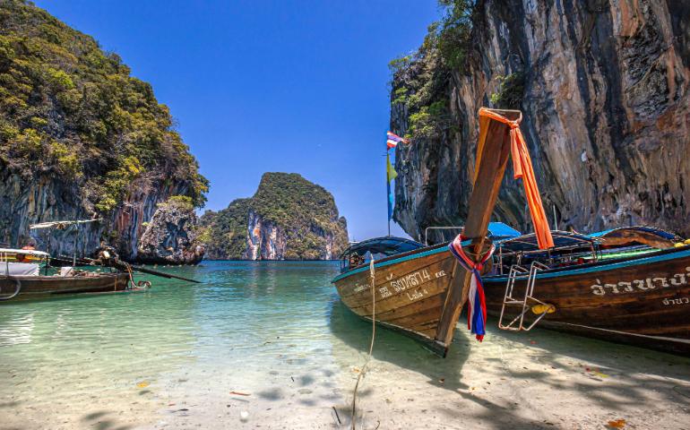 View of traditional Thai long-tail boats moored in Ao Nang's clear waters
