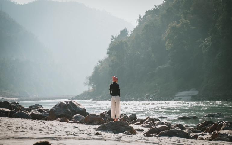 A woman stands by the scenic river in Rishikesh, India
Image Credit: Gokul Gurang/Pexels