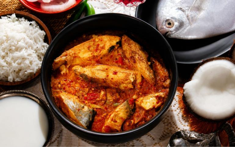 Traditional Indian fish curry served with steamed rice, fresh coconut, and vibrant spices.