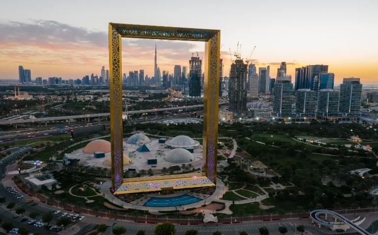 View of Dubai Frame with cityscape backdrop at sunset.
