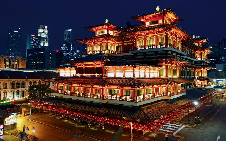 Night view of the beautifully lit Buddha Tooth Relic Temple in Singapore's Chinatown.