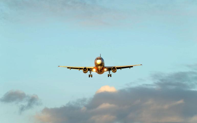 Airplane descends through a clear blue sky