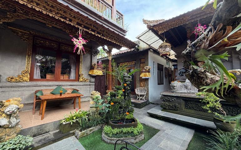 Balinese cafe showcasing intricate carvings, lush greenery, and cultural decor.