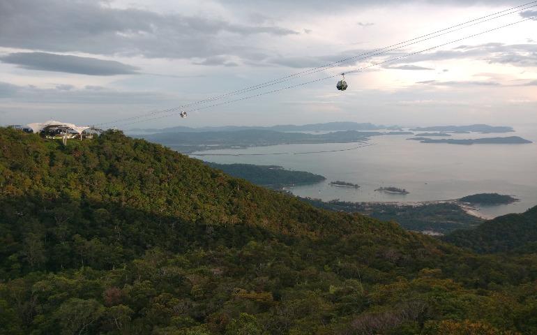 Breathtaking aerial view of Langkawi's cable car with lush forests and serene coastline.