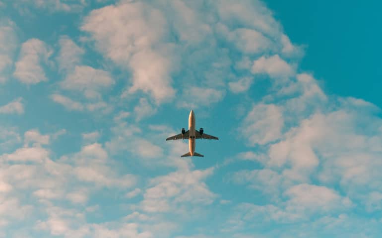 White airplane flying in the blue sky
