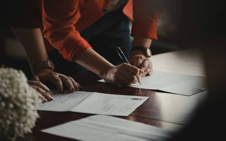 People signing documents on a table
