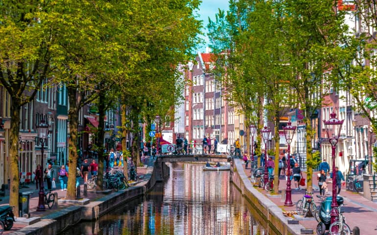 People walking besides the canal in Amsterdam