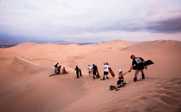 A group of people on top of a sand dune