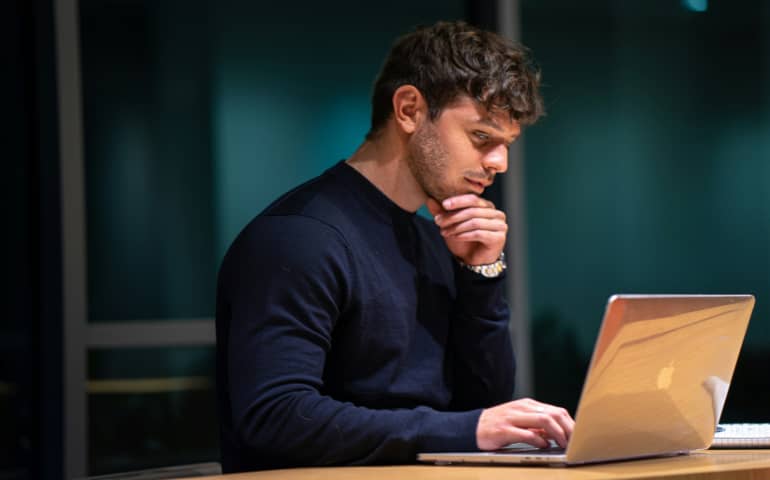 A man sitting in front of a macbook