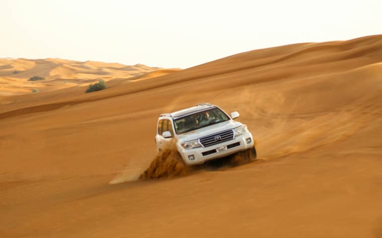 White SUV on brown sand