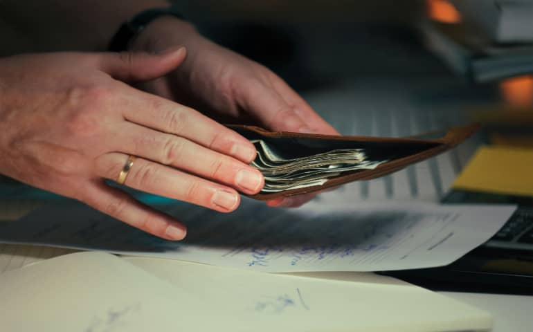 A person removing cash from his wallet