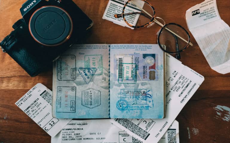 A passport, visa, boarding pass, camera and other travel essentials