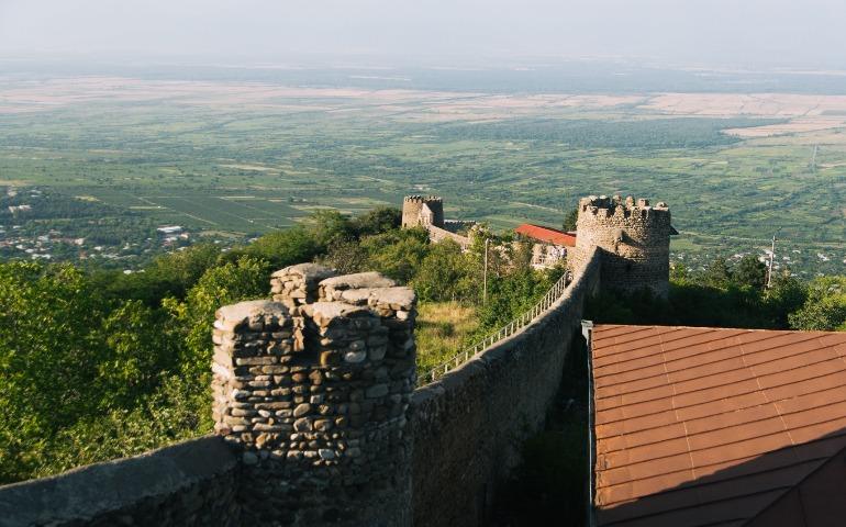 A panoramic view of the historic Sighnaghi Wall and lush landscape in Georgia.
Image Credit: Алексей Вечерин/Pexels