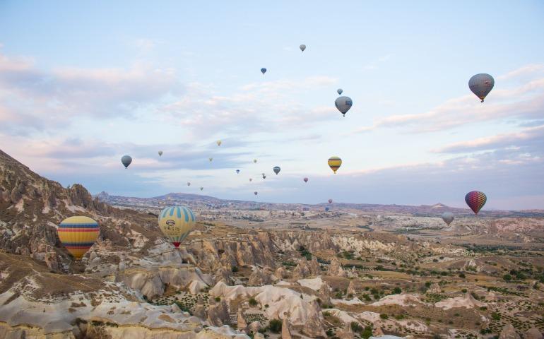 Vibrant hot air balloons floating over the stunning rocky terrain of Cappadocia at dawn.
Image Credit: Ann Zzz/Pexels 
